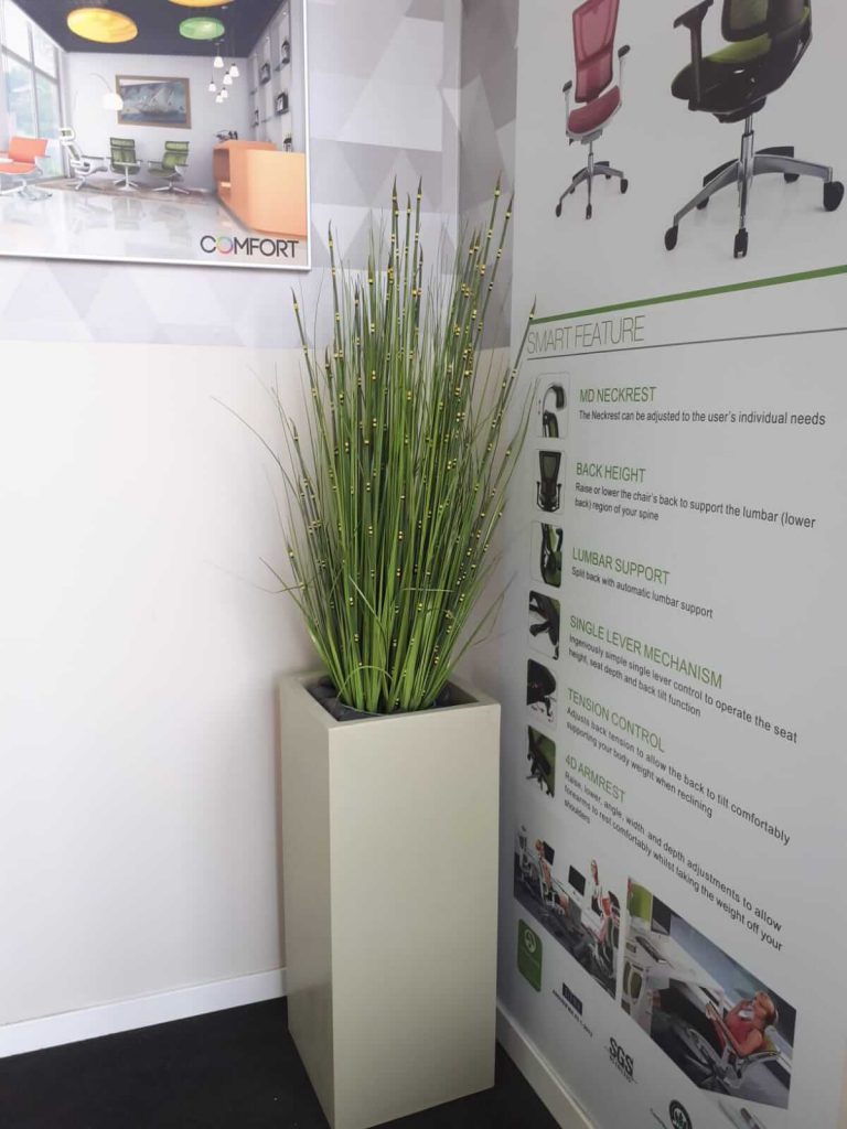 עציץ מלאכותי עם כד לבן בפינה